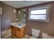 Bathroom with a sink, toilet, mirror and a window providing natural light at 2228 Emory St, Covington, GA 30014