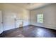 Bedroom with dark hardwood floors, white trim, and a window providing natural light at 2228 Emory St, Covington, GA 30014