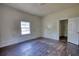 Empty bedroom featuring hardwood floors, white trim, and a window providing natural light at 2228 Emory St, Covington, GA 30014