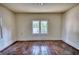 Empty bedroom featuring hardwood floors, white trim, and a window providing natural light at 2228 Emory St, Covington, GA 30014