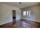 A bedroom featuring hardwood floors, a window, and an open door at 2228 Emory St, Covington, GA 30014