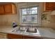 Close up of a kitchen sink with a window, wood cabinets and minimal counter space at 2228 Emory St, Covington, GA 30014
