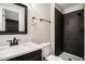 Modern bathroom features a sleek vanity, elegant mirror, and a contemporary shower with dark tiling at 2406 Tilson Rd, Decatur, GA 30032