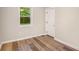 Cozy bedroom features fresh paint, wood-look floors, a window, and a door, creating a serene retreat at 2406 Tilson Rd, Decatur, GA 30032