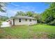 Rear exterior view of the home with a lush lawn and a white brick foundation and siding at 2406 Tilson Rd, Decatur, GA 30032
