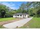 Exterior view of a well maintained home with long driveway, landscaping, and mature trees at 2406 Tilson Rd, Decatur, GA 30032