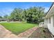 Well-kept front yard with lush green grass, manicured landscaping, and a charming white painted brick home at 2406 Tilson Rd, Decatur, GA 30032