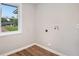 Bright laundry room features hookups, wood-look floors, and a window with a view of the neighborhood at 2406 Tilson Rd, Decatur, GA 30032