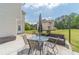 Back patio with outdoor dining furniture, umbrella, and a grill in a green back yard at 4023 Port Springs Trl, Snellville, GA 30039