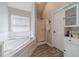 Modern bathroom featuring a corner tub, glass-enclosed shower, and ample cabinet space at 4023 Port Springs Trl, Snellville, GA 30039