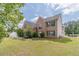 Lovely two-story brick home features a green lawn and a patio with outdoor furniture at 4023 Port Springs Trl, Snellville, GA 30039