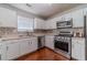 Well-lit kitchen featuring white cabinets, mosaic backsplash, and stainless steel appliances at 4023 Port Springs Trl, Snellville, GA 30039