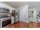 The kitchen is equipped with stainless steel appliances, white cabinets, hardwood floors, and light countertops at 4023 Port Springs Trl, Snellville, GA 30039
