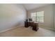 Cozy office with neutral paint, plush carpeting and a wooden desk beneath a bright window at 4023 Port Springs Trl, Snellville, GA 30039