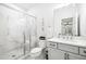 This bathroom features a glass shower, white cabinets, lots of natural light and neutral finishes at 6807 Prelude Dr, Atlanta, GA 30328