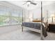 This bedroom features hardwood floors, a four-poster bed, a ceiling fan, and large windows at 6807 Prelude Dr, Atlanta, GA 30328