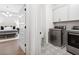 A bedroom suite includes a laundry room with gray-patterned tile and stainless steel washer and dryer at 6807 Prelude Dr, Atlanta, GA 30328