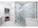 A glass-enclosed shower features marble-style tile, a bench, and a door to the walk-in closet at 6807 Prelude Dr, Atlanta, GA 30328