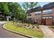 Brick townhouse with manicured landscaping, green grass, and wrought iron gate entrance at 6980 Roswell Road # A8, Atlanta, GA 30328