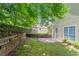 Home's backyard features tiered retaining walls, grass, and trees at 12241 Cypress Way, Fayetteville, GA 30215