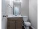 Powder room featuring a pedestal sink, toilet, and a large mirror at 12241 Cypress Way, Fayetteville, GA 30215