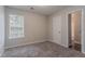 Bright bedroom featuring neutral walls, plush carpeting, and a sunlit window, creating a serene space at 12241 Cypress Way, Fayetteville, GA 30215