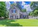 Charming two-story home with neutral siding, dark shutters, and a well-manicured lawn on a sunny day at 12241 Cypress Way, Fayetteville, GA 30215
