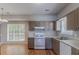 Functional kitchen features wood floors, painted cabinets, a white gas range, and stainless sink at 12241 Cypress Way, Fayetteville, GA 30215