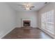 Inviting living room features wood floors, a brick fireplace, ceiling fan, and bright window at 12241 Cypress Way, Fayetteville, GA 30215