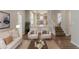 Cozy living room featuring a sofa, two chairs, and a view into the kitchen and stairs at 12241 Cypress Way, Fayetteville, GA 30215