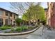 Beautiful brick apartment building courtyard with a stone pathway and seating areas surrounded by lush green plants and landscaping at 170 Boulevard Se # 115E, Atlanta, GA 30312