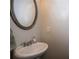 A half bathroom featuring a sleek vanity, sink, and an elegant round mirror at 3005 Devoncroft Se St, Smyrna, GA 30080