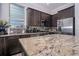 Modern kitchen featuring dark cabinets, stainless steel appliances, and a granite countertop island at 3005 Devoncroft Se St, Smyrna, GA 30080