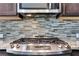 Close up of range with stainless steel backsplash and granite countertops at 3005 Devoncroft Se St, Smyrna, GA 30080