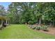 Manicured backyard with a lush lawn, flower beds, and mature trees offering a serene outdoor space at 878 Park Creek Sw Ct, Marietta, GA 30064