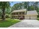 Traditional brick home with a spacious driveway and a well-kept lawn, surrounded by mature trees at 878 Park Creek Sw Ct, Marietta, GA 30064