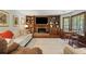 Spacious living room with built-in bookshelves, fireplace, and access to a sunroom with large windows at 878 Park Creek Sw Ct, Marietta, GA 30064