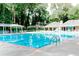 Bright community swimming pool with lounge chairs, umbrellas, and trees surrounding at 878 Park Creek Sw Ct, Marietta, GA 30064