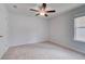 Neutral bedroom with a ceiling fan, plush carpet, and a large window bringing in natural light at 17 Camellia Dr, Fairburn, GA 30213