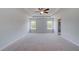 Large main bedroom boasts a tray ceiling, ceiling fan, plush carpet, and two windows at 17 Camellia Dr, Fairburn, GA 30213