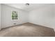 Cozy bedroom with neutral walls, carpet, and a window overlooking green trees at 2035 Stilesboro Nw Dr, Kennesaw, GA 30152