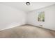 Bright, empty bedroom with neutral walls, carpet, and a window overlooking green trees at 2035 Stilesboro Nw Dr, Kennesaw, GA 30152