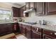 Modern kitchen with dark wood cabinets, granite countertops, and a gas cooktop at 4060 Brumby Ln, Cumming, GA 30041