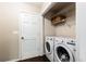 Laundry room with white washer and dryer, wire rack, and door to outside at 511 Pine Springs Se Trl, Marietta, GA 30067