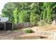 View of the backyard showing the fenced perimeter, storage shed, and mature trees at 1132 Britley Park Ln Ln, Woodstock, GA 30189