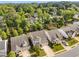 An aerial view of a neighborhood with mature trees and manicured lawns surrounding well-maintained homes at 122 Grove View Rd, Woodstock, GA 30189