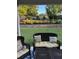 A close up view of the covered back patio showcasing comfortable wicker furniture and beautiful landscaping at 122 Grove View Rd, Woodstock, GA 30189