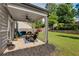 Inviting covered back patio featuring a ceiling fan, outdoor seating, and a view of the landscaped backyard at 122 Grove View Rd, Woodstock, GA 30189