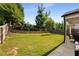 Well-maintained backyard featuring a lush lawn, tiered landscaping, and a view of the covered patio at 122 Grove View Rd, Woodstock, GA 30189