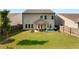 Aerial view of the home's backyard, complete with a large lawn and inviting covered patio at 122 Grove View Rd, Woodstock, GA 30189